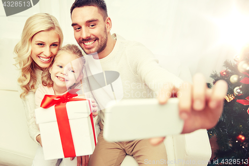 Image of family taking selfie with smartphone at christmas