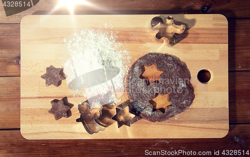 Image of close up of ginger dough, molds and flour on board