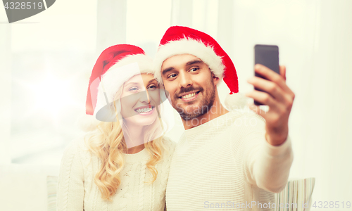 Image of couple taking selfie with smartphone at christmas