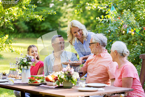 Image of happy family having dinner or summer garden party