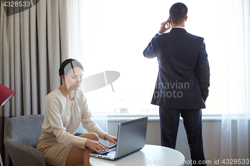 Image of business team with laptop working at hotel room