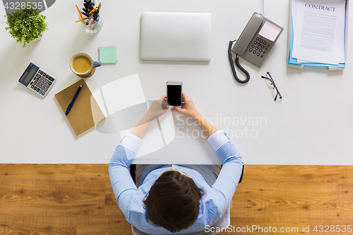 Image of businesswoman with smartphone working at office