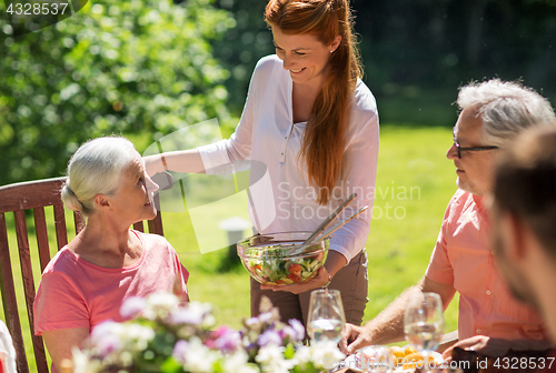 Image of happy family having dinner or summer garden party