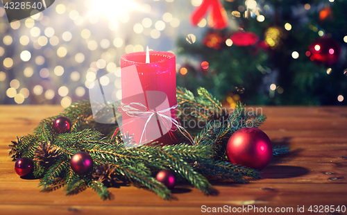 Image of fir branch wreath with candle on wooden table