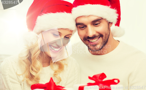 Image of happy couple at home with christmas gift boxes