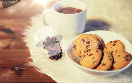 Image of cups of hot chocolate with cookies on fur rug