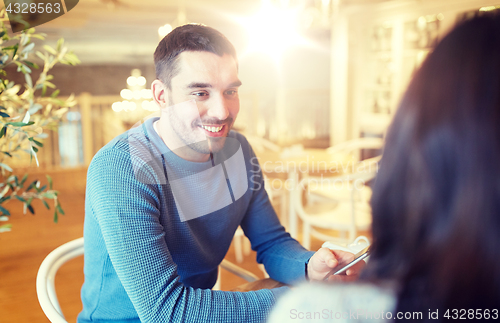 Image of happy couple talking at cafe or restaurant