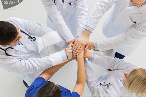 Image of group of doctors with hands together at hospital