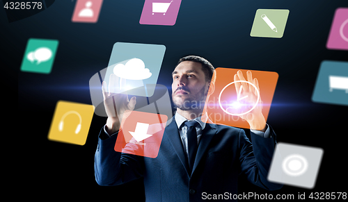 Image of businessman with menu icons on virtual screen