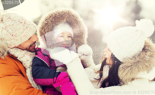 Image of happy family with child in winter clothes outdoors