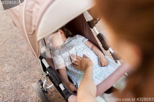 Image of mother with child sleeping in stroller