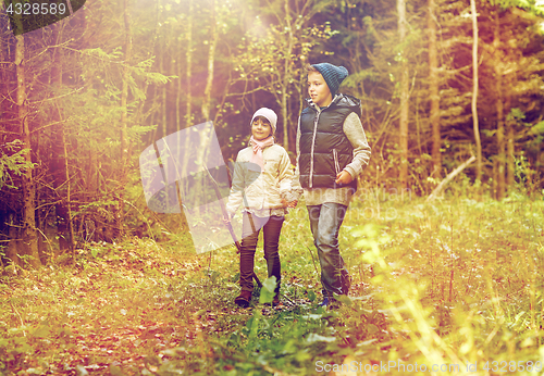Image of two happy kids walking along forest path