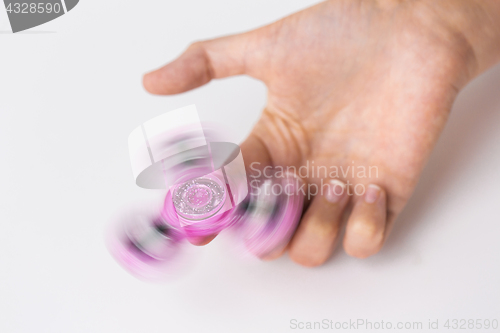 Image of close up of hand playing with fidget spinner