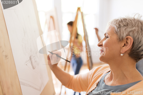 Image of woman artist with pencil drawing at art school