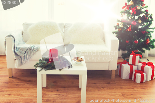 Image of sofa, table and christmas tree with gifts at home