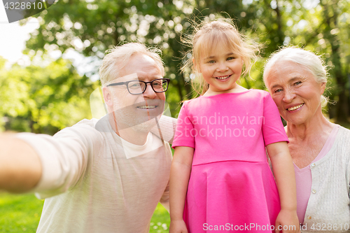 Image of senior grandparents and granddaughter selfie