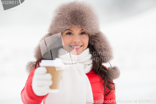 Image of happy woman in winter fur hat with coffee outdoors