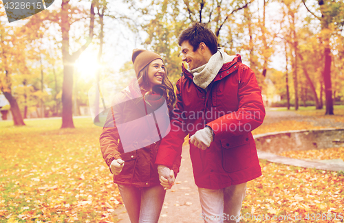Image of happy young couple walking in autumn park