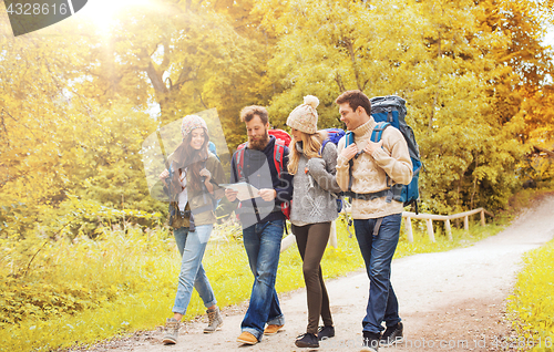 Image of group of smiling friends with backpacks hiking