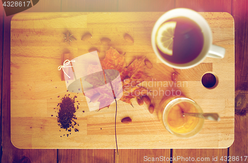 Image of cup of lemon tea and honey on wooden board