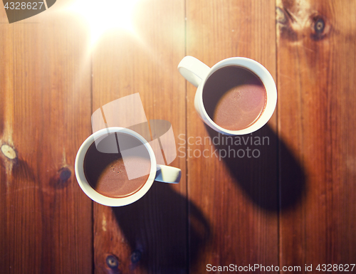 Image of cups of hot chocolate or cocoa drinks on wood