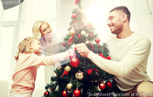 Image of happy family decorating christmas tree at home