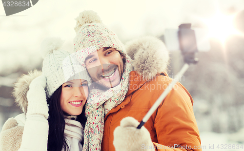 Image of happy couple taking selfie by smartphone in winter