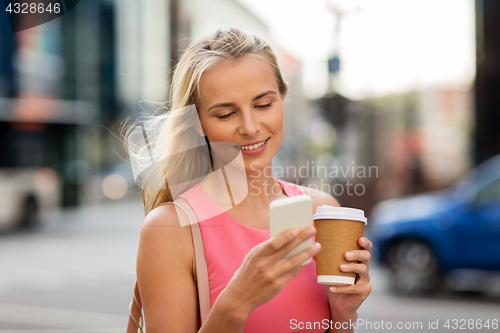 Image of woman with coffee and smartphone in city