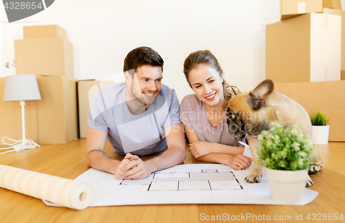 Image of couple with boxes, blueprint and dog at new home