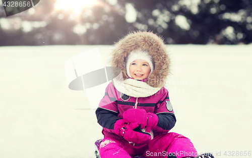 Image of happy little kid on sled outdoors in winter