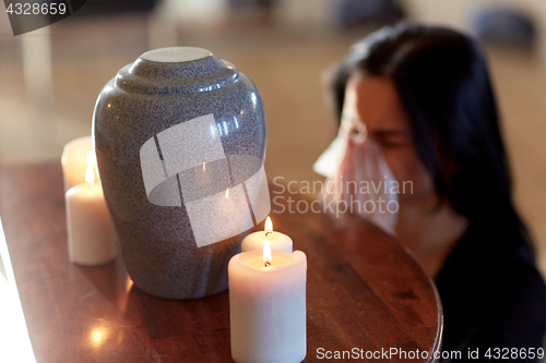 Image of woman with cremation urn at funeral in church