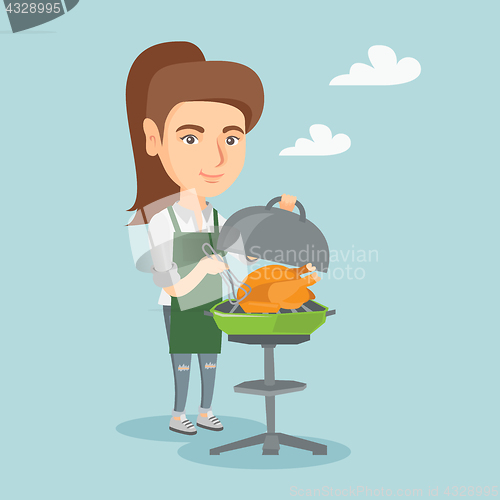 Image of Caucasian woman cooking chicken on the barbecue.