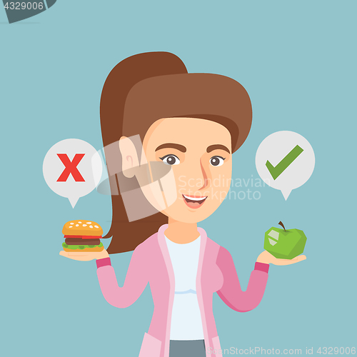 Image of Woman choosing between hamburger and cupcake.