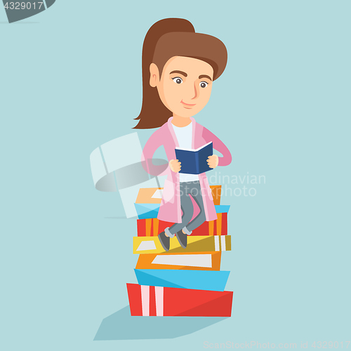 Image of Caucasian student sitting on a huge pile of books.