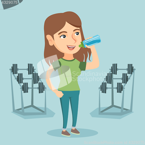 Image of Young caucasian sportswoman drinking water.
