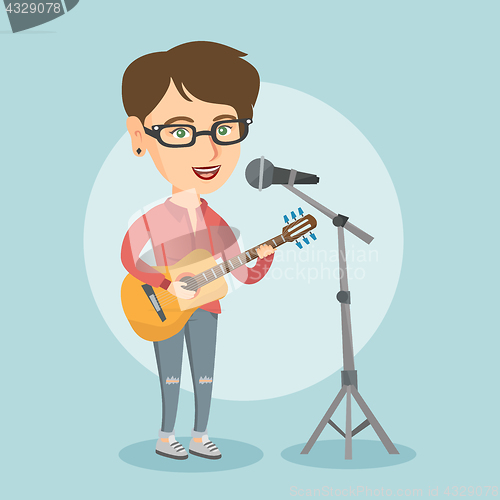 Image of Woman singing into a mic and playing the guitar.