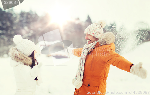 Image of happy couple playing with snow in winter