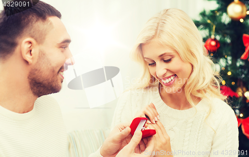 Image of man giving woman engagement ring for christmas