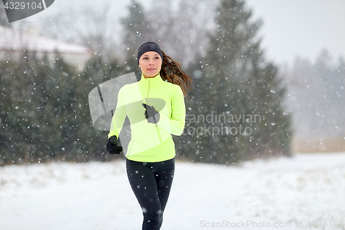 Image of happy woman running outdoors in winter