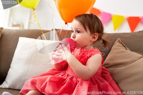 Image of baby girl drinking from sippy cup at birthday