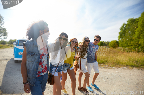 Image of smiling happy young hippie friends at minivan car