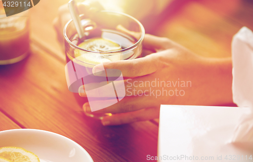 Image of close up of ill woman drinking tea with lemon