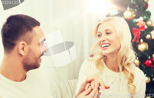 Image of man giving woman engagement ring for christmas