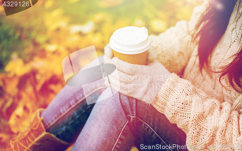 Image of close up of woman drinking coffee in autumn park