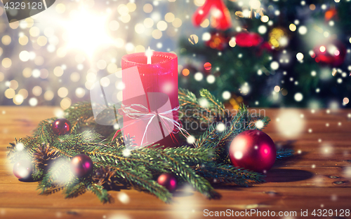 Image of fir branch wreath with candle on wooden table