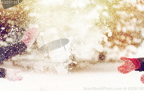 Image of happy friends playing with snow in winter