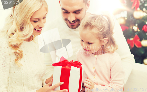 Image of happy family at home with christmas gift box