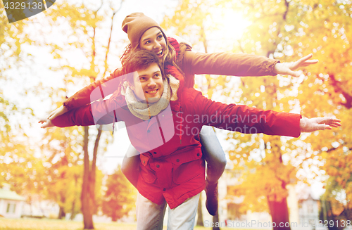 Image of happy young couple having fun in autumn park