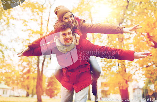 Image of happy young couple having fun in autumn park