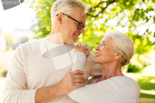 Image of happy senior couple hugging at summer park